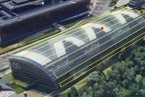 Aerial view of a modern glass-roofed building, part of the European Court of Justice complex in Luxembourg, surrounded by trees and adjacent roads