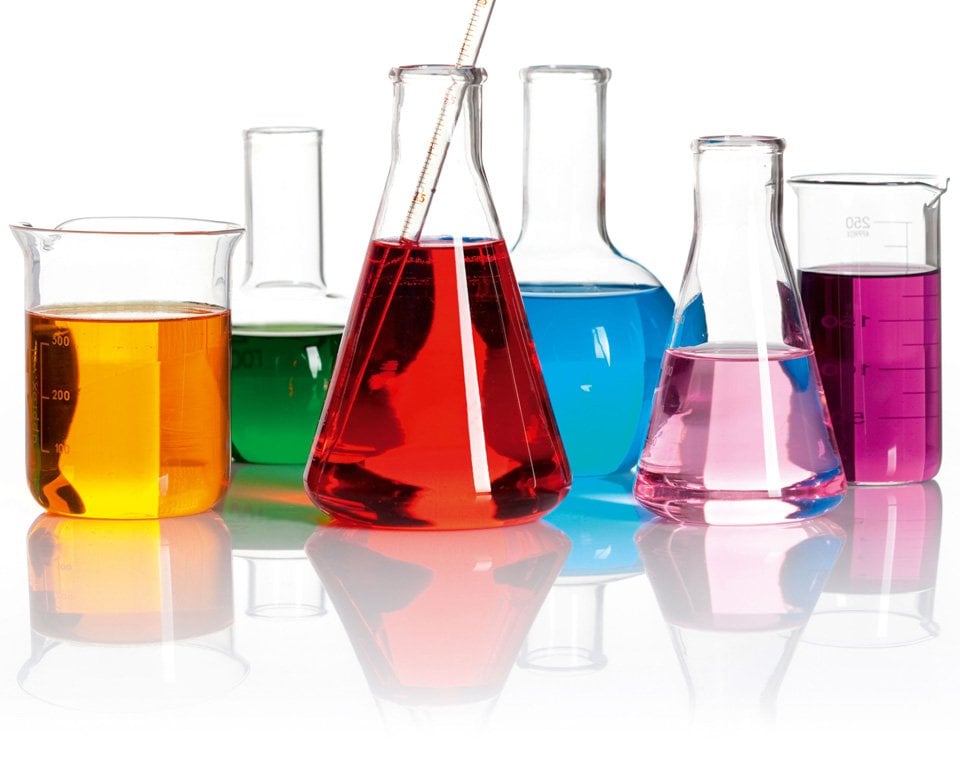 Vätskor i flera olika färggranna färger i olika typer av laboratorieflaskor.