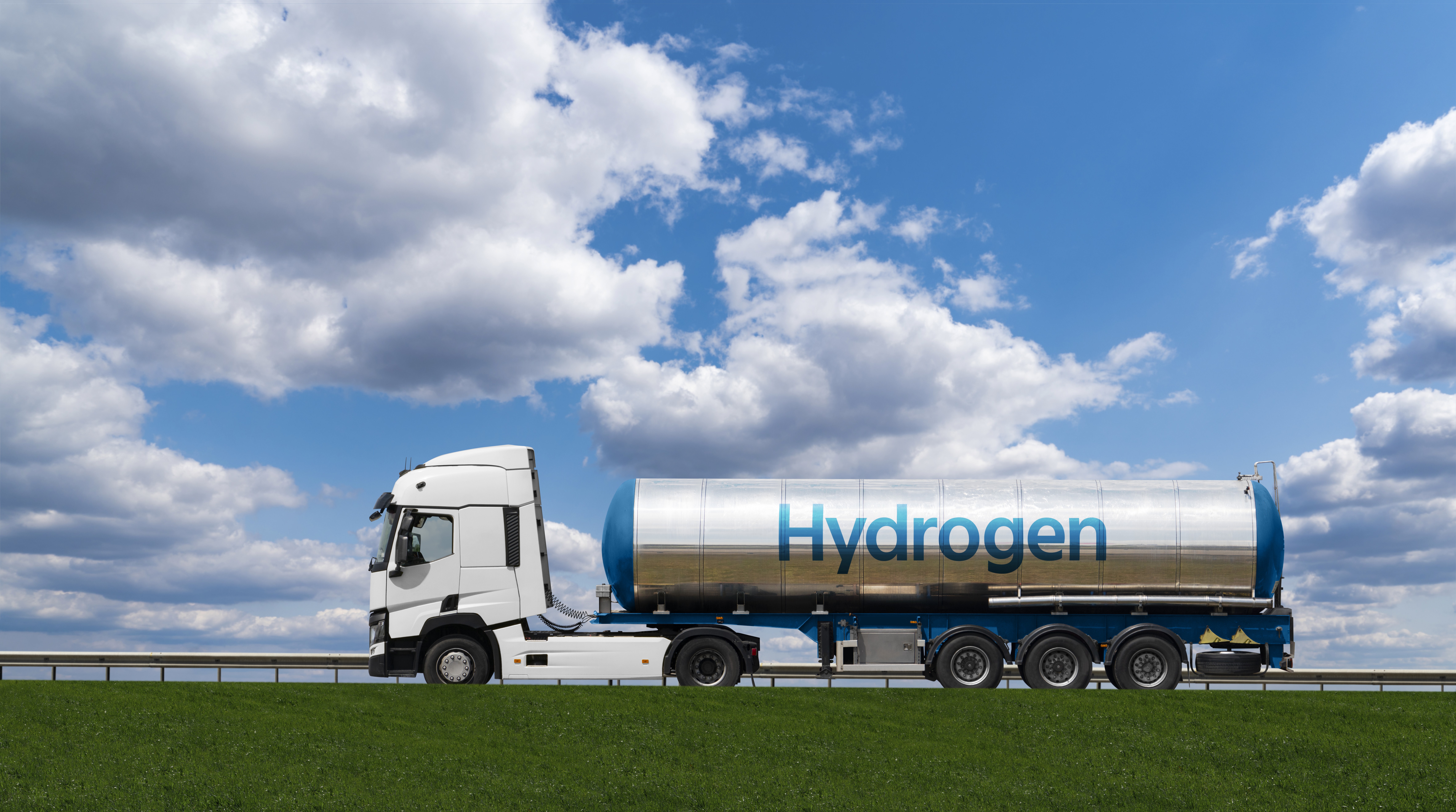Hydrogen transport truck on highway with blue sky and clouds