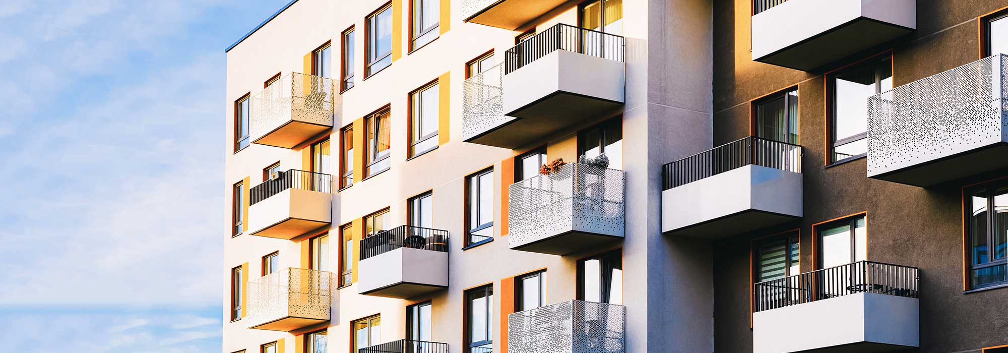 Flerfamiljshus med många lägenheter med balkonger. 